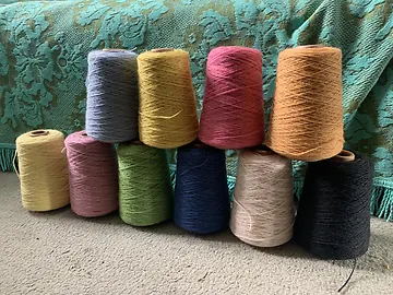 Cones of coloured yarn stacked together